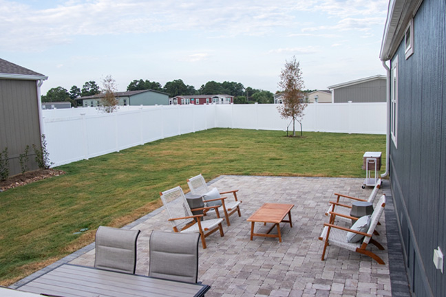 The exterior of a mobile home with outdoor seating ideas and a stone patio