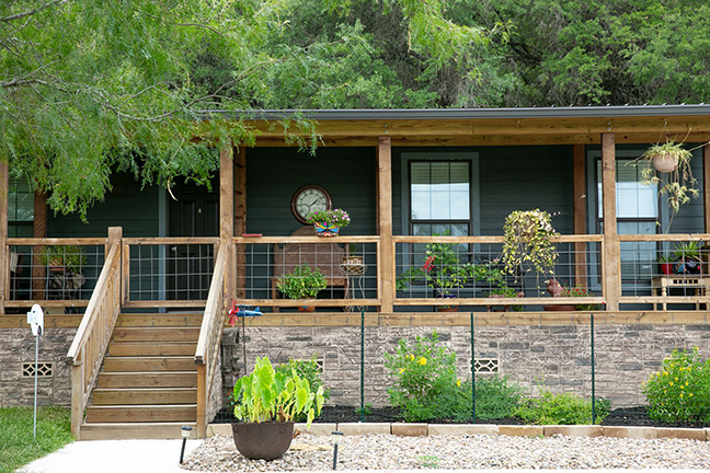 The front porch of a manufactured home with a decorative fence