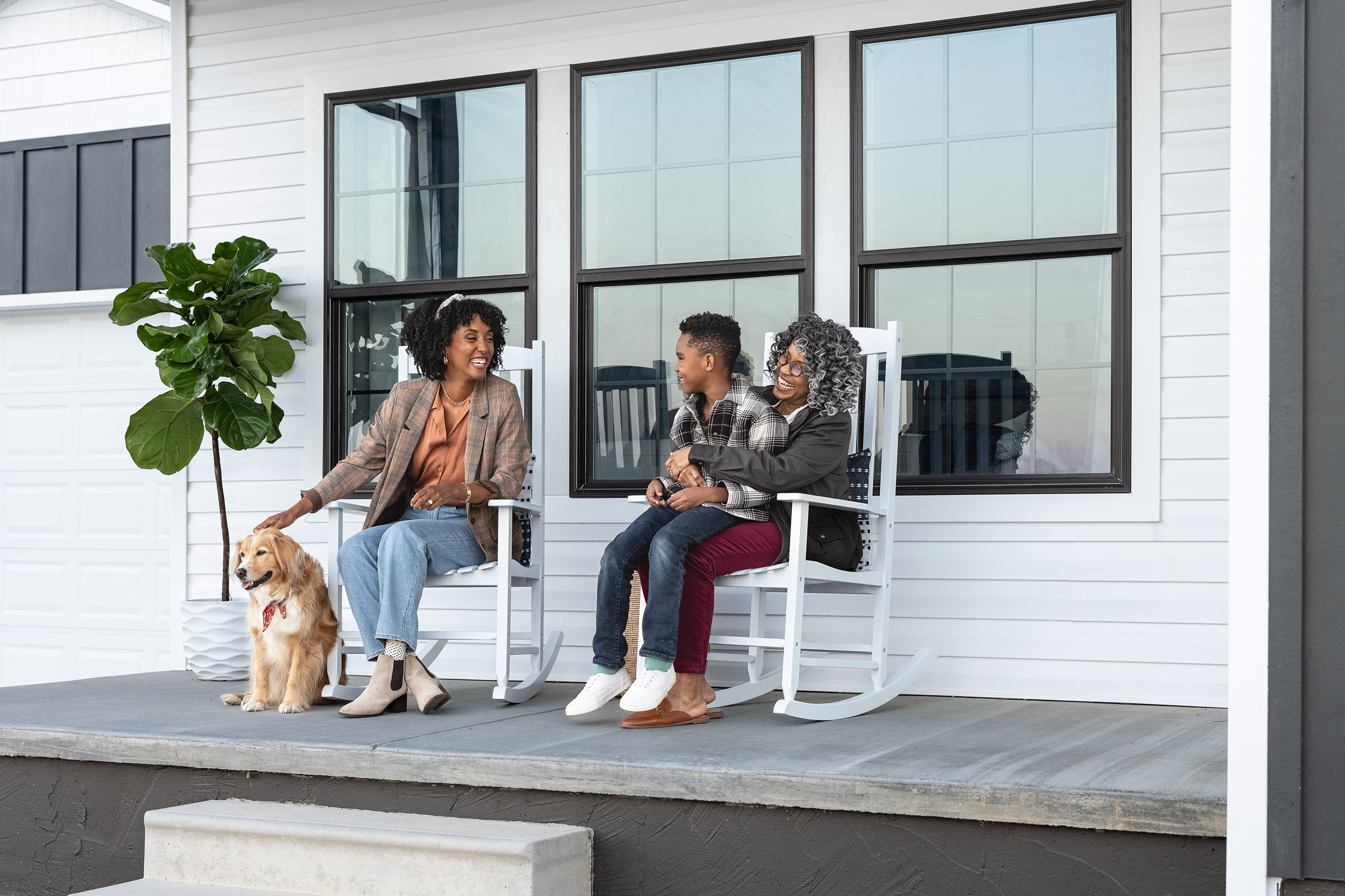 A family with a dog on the porch of their manufactured home