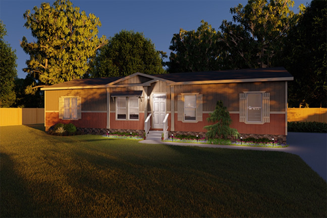 The front yard of a tan and red manufactured home at dusk with a lighted walkway