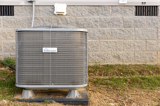 An outdoor air conditioning system in front of the foundation of a manufactured home